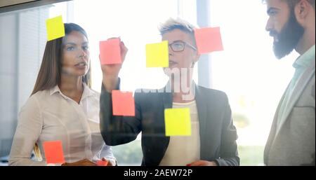 Picture of designers sticking notes in office Stock Photo