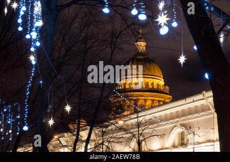 Beautiful night view of the luminous dome of St. Isaac's Cathedral framed by Christmas holiday illumination (St. Petersburg, Russia) Stock Photo