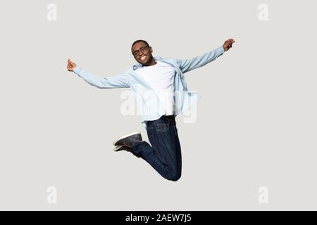 Full length overjoyed millennial african american man jumping. Stock Photo