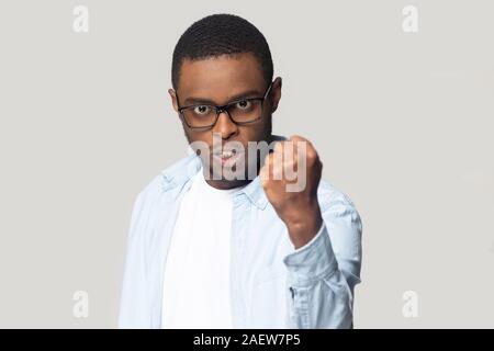Angry annoyed african american millennial man showing clenched fist. Stock Photo