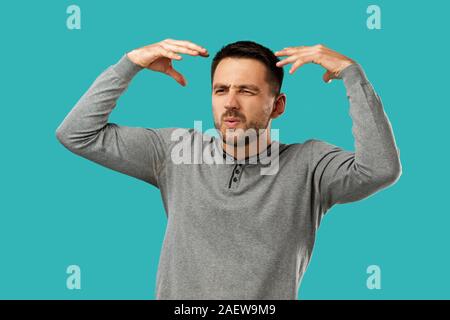 portrait of furious enraged bearded man shouting and screaming isolated on blue background Stock Photo