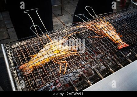 Grill prawn cooking seafood. Freshly grilled delicious lobsters. Lobster bbq. Street food. Stock Photo