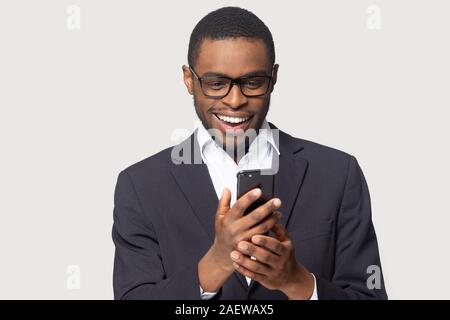 Head shot cheerful millennial african american guy holding smartphone. Stock Photo