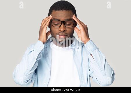 Tired unhealthy young african american guy having high blood pressure. Stock Photo