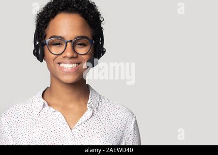 Young ethnic woman operator wearing wireless headset with mic portrait. Stock Photo