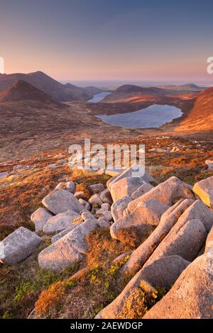 Sunrise over the Mourne Mountains and lakes in Northern Ireland. Photographed from the peak of Slieve Loughshannagh.