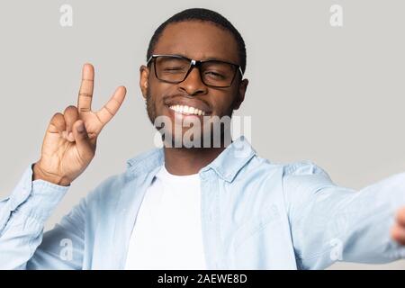 Smiling african american young guy smiling, winking, taking selfie. Stock Photo