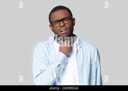 Studio head shot young african american guy suffering from angina. Stock Photo