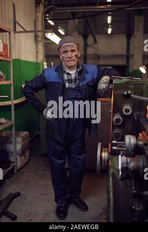 Portrait of manual worker standing in work uniform and looking at camera in the factory Stock Photo