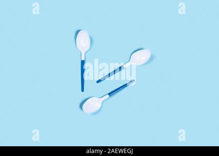 So beautiful and so dangerous plastic spoons. Environmental problem of plastic rubbish pollution. Central composition. Stock Photo