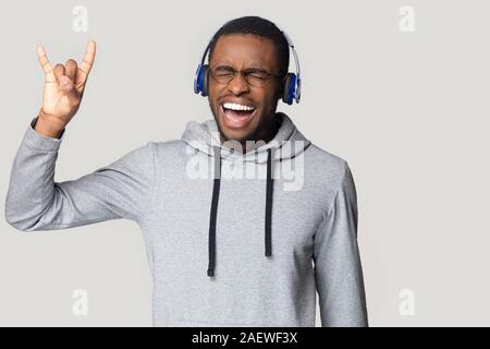 Crazy happy young african american male melomaniac keen on music. Stock Photo