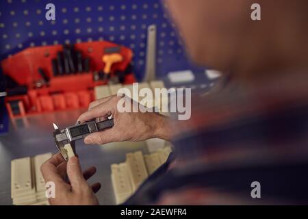Close-up of man holding insstrument of measurement and measuring the detail Stock Photo
