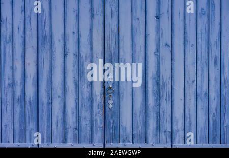 A rustic old barn door, painted lavender blue, in Provence, France. Stock Photo