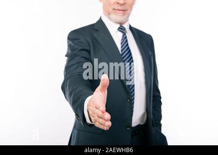 Close up portrait of old businessman reaching out his hand to greet Stock Photo