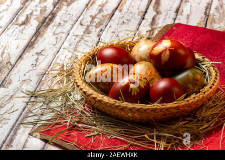 Traditional easter painted eggs in straw basket red napkin Stock Photo