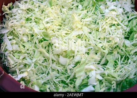 Finely chopped cabbage for hikers. A salad that is prepared and waiting for a stew that is still cooked. Stock Photo