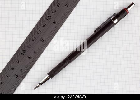 Clutch pencil and steel ruler on white squared drawing paper Stock Photo