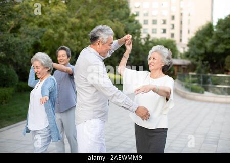 Happy senior couple dancing in park Stock Photo