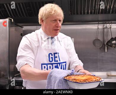 Prime Minister Boris Johnson holds a freshly baked pie during a visit to the Red Olive in Derby, while on the General Election campaign trail. Stock Photo