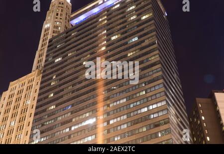 Chicago, IL - Circa 2019: Night time exterior establishing shot photo of a big city downtown apartment or office building illuminated to light up skyl Stock Photo