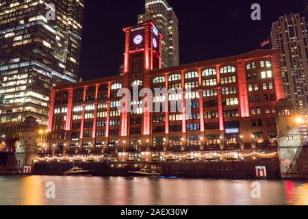 Chicago, IL, Circa 2019: Night time exterior establishing shot of red clock tower Whirlpool building architecture in Chicago along famous river walk Stock Photo
