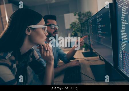 Profile photo of it specialist guy lady two business people night coworking watch together indicate monitor testing debugging java script code smart Stock Photo