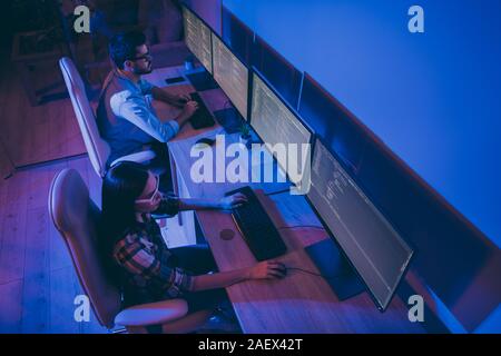 High angle above view photo of it specialist two guy lady business people working late night together solving problems bugs check back-end code Stock Photo