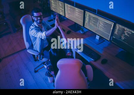 Good job. High angle above view photo of it specialist guy lady two business people work night did code together for startup skilled professionals Stock Photo