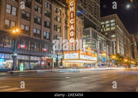 Chicago, IL - Circa 2019: Chicago landmark theatre famous venue in downtown. Night time exterior establishing shot long exposure of traffic light trai Stock Photo