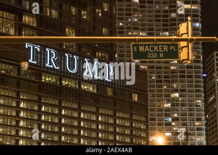 Chicago, USA - Circa 2019: Trump building sign positioned next to wacker avenue street sign at night for funny slang term to insult Donald Trump as pr Stock Photo