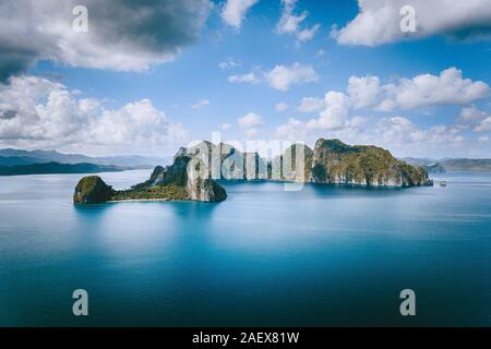 El Nido, Palawan, Philippines. Panoramic aerial view lonely tourist boat in open sea with exotic tropical Pinagbuyutan island standing out in ocean Stock Photo