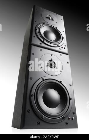 Modern black loudspeakers towering on top of each other, studio shot on gradient gray background Stock Photo