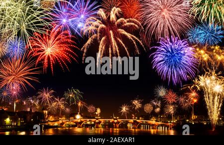 Cheerful fireworks display in the city, with lots of colorful bangs rising high into the night sky, with black copyspace Stock Photo