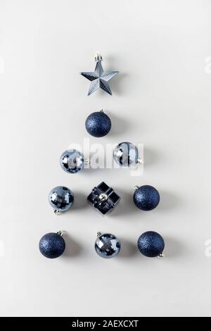 alternative, Christmas tree of classic blue balls and stars on neutral grey. Close up. Xmas. Holiday greeting creative card. Trendy color of the 2020 Stock Photo