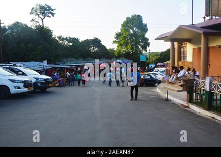 The Parking area of Elephant Falls, Upper Shillong, Meghalaya  with rows of car, people roaming around, trees, open sky, selective focusing. Stock Photo