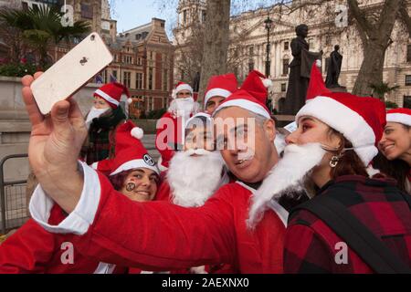 London, UK, 11 December 2019: Jonathan Bartley, the Green Party co-leader, dressed in a Santa costume and took selfies with activists as Extinction Rebellion wrapped up their 12 Days of Crisis demonstrations with a group of Santas who visited the headquarters of all the political parties to find out whether they had been naughty or nice on environmental issues. Conservtive Party HQ got coal instead of presents becasue of their manifesto policies being weak onthe environment and becasue so many Tory candidates had refused to attend environmental hustings. Anna Watson/Ģ����ý Live News Stock Photo