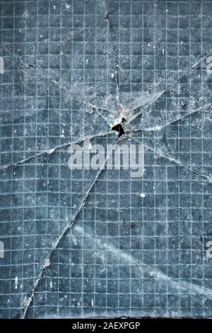 tempered glass with a crack and a hole into it Stock Photo