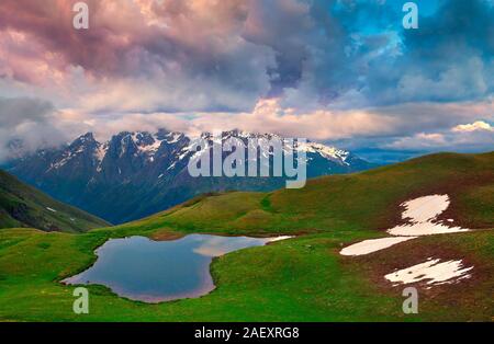 Dramatic summer sunset on the lake Koruldi at the foot of Mt. Ushba. Upper Svaneti, Mestia, Georgia, Europe. Caucasus mountains. Stock Photo