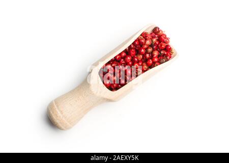 Pink peppercorns on a wooden scoop on a white background Stock Photo
