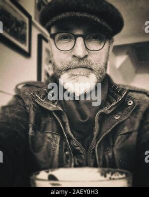 Middle aged male figure wearing spectacles with greying beard Stock Photo