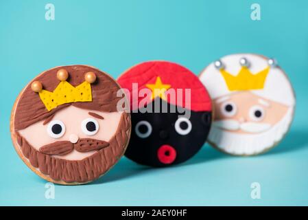closeup of some homemade cookies in the shape of the three wise men on a blue background Stock Photo