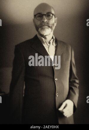 Middle aged male figure wearing spectacles  and jacket with greying beard Stock Photo