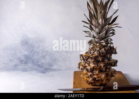 Pineapple on wood texture background. Whole and sliced ​​tropical pineapple on a wooden board. Top view with place for your text. Stock Photo