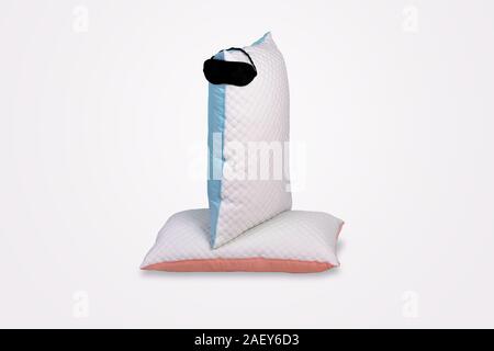 Personofied quilted pillows with sleeping mask on gray background. Soft cushion for comfortable sleep and sweet dreaming Stock Photo