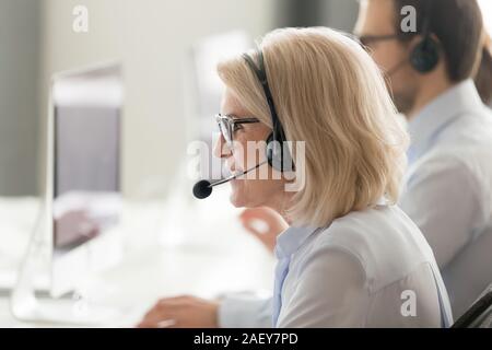 Middle-aged female operator consult client in customer service Stock Photo