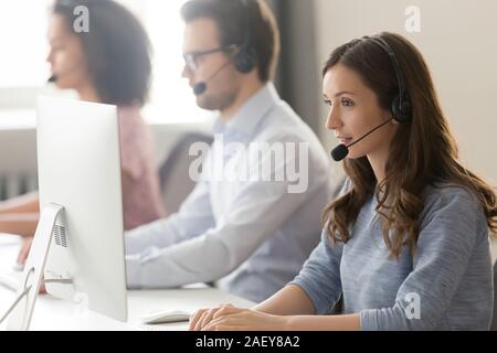 Female agent in headset consult client online using pc Stock Photo