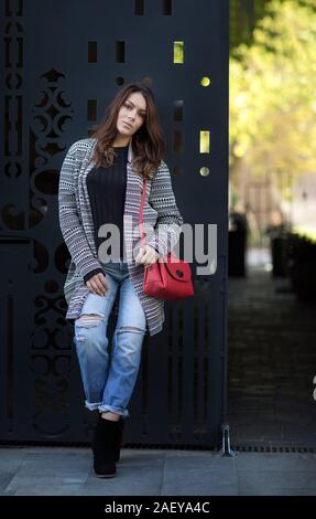 Lonely sad woman deep in thoughts leaning against the wall Stock Photo