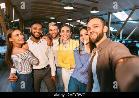 Friendly colleagues taking selfie at coffee break, posing together to camera Stock Photo