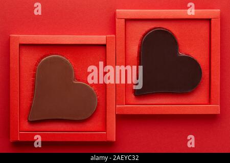 Valentines day chocolate hearts in red box on red background, copy space Stock Photo