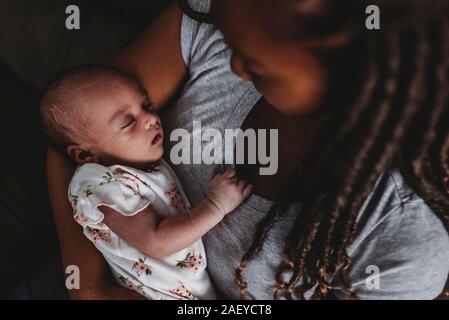 Precious multiracial infant peacefully sleeping in motherâ€™s embrace Stock Photo